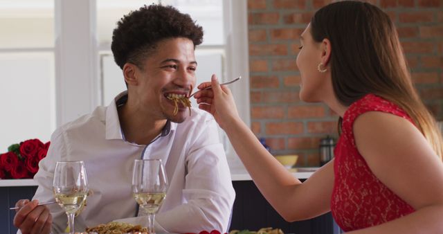 Happy biracial couple having valentine's day celebration meal at home. valentine's day celebration, romance and quality time together at home.