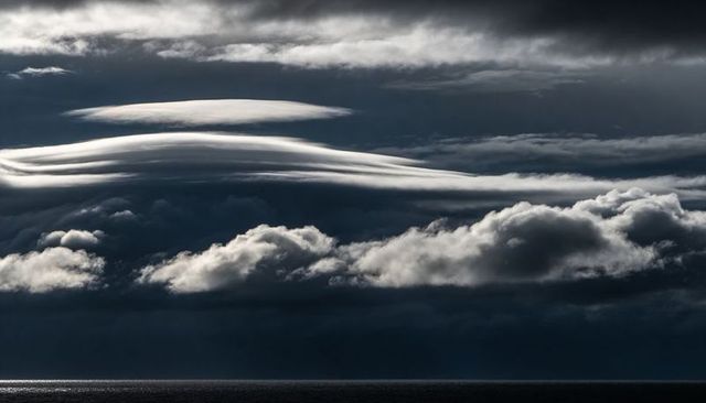 Lenticular Cloud Bands Dominating Stormy Ocean Horizon with Narrow Sun Glint