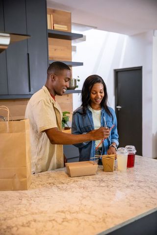 Friends Enjoying Casual Takeout Meal Together at Modern Kitchen