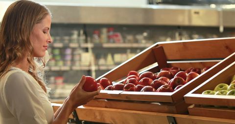 Woman choosing apples at grocery store