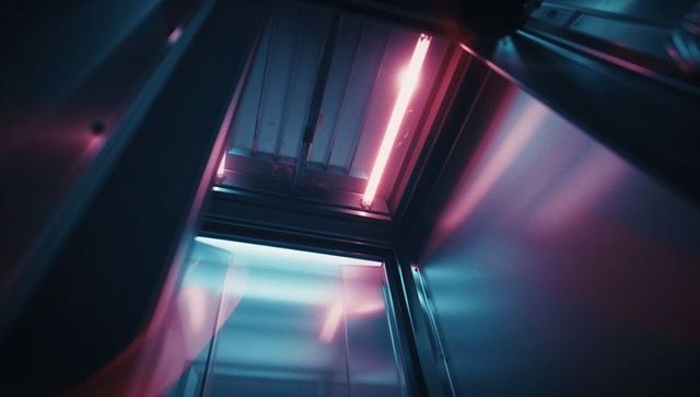 Futuristic neon inside industrial metal chamber illuminated by fluorescent light