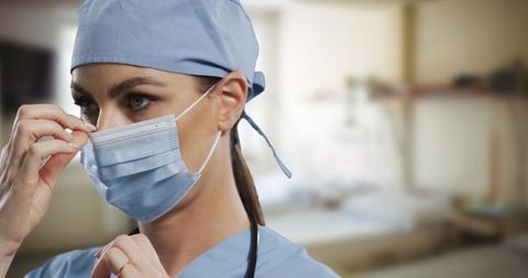 Surgeon Adjusting Face Mask in Hospital Setting