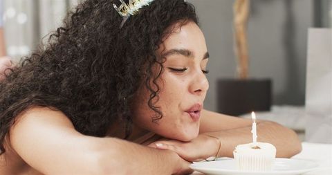 Happy Woman Blowing Candle on Cupcake During Birthday Celebration