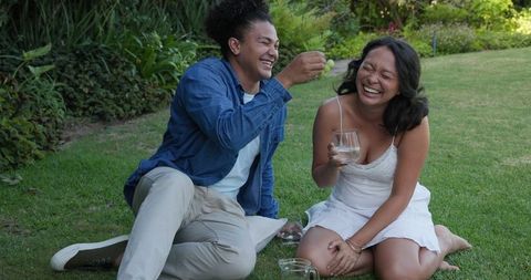 Joyful couple laughing at outdoor wedding celebration
