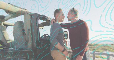 Sunlit mature male couple embracing by black suv at coastal overlook with turquoise overlay