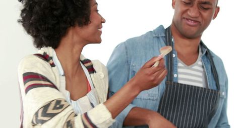 Couple Sharing Joyful Cooking Moment in Sunlit Kitchen