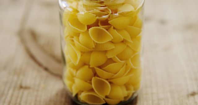 Close-Up of Uncooked Pasta Shells in Glass Jar on Wooden Table - Download Free Stock Images Pikwizard.com