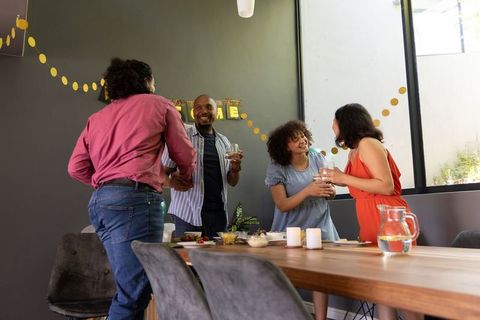 Friends Gather at Home Celebrating with Food and Drinks