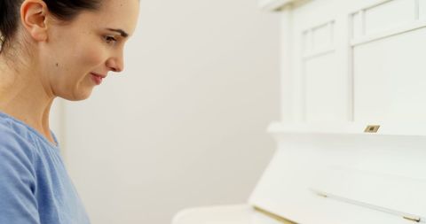 Happy Woman Practicing on a Minimalist White Piano - Download Free Stock Images Pikwizard.com