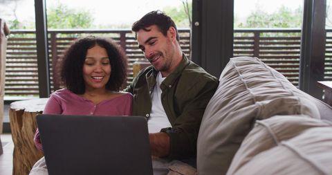 Happy Couple Relaxing with Laptop at Home