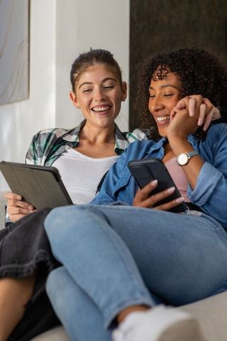 Diverse Friends Relaxing and Laughing with Tablet and Smartphone