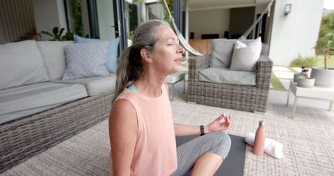 Caucasian Woman Meditating Peacefully on Patio Yoga Mat