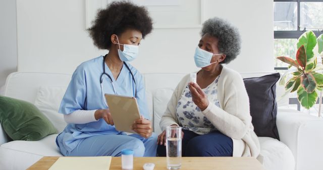 Nurse Assisting Elderly Woman with Medication and Care on Sofa - Download Free Stock Images Pikwizard.com