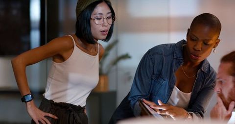 Diverse Businesswomen Collaborate on Project in Evening Office