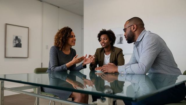 Discussing strategy: diverse team collaborating at glass table in modern minimalist office