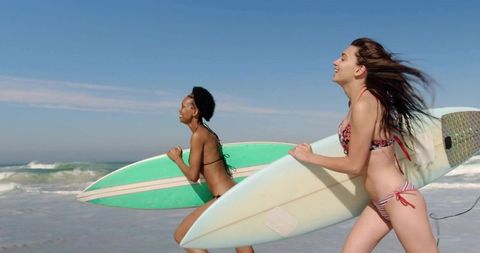 Young Women Enjoying Surfing at Sunny Beach