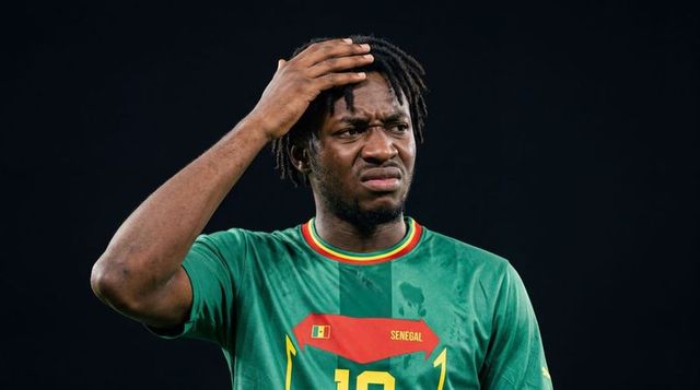 Senegal footballer holding head frowning wearing no 10 jersey showing frustration