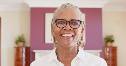 Senior Woman with Glasses Smiling in Elegant Living Room