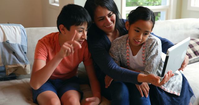 Mother and Children Using Tablet on Sofa Laughing and Enjoying Time Together - Download Free Stock Images Pikwizard.com