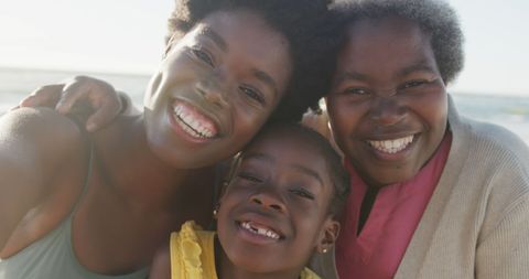 African American Family Smiling Together on Sunny Beach