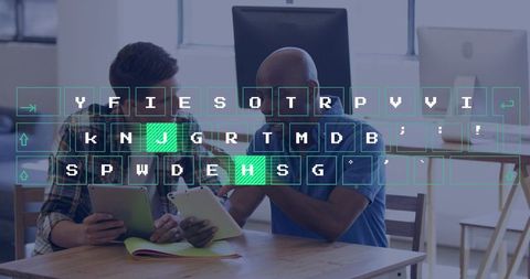 Pointing man guiding colleague on tablet with digital keyboard overlay in coworking workspace