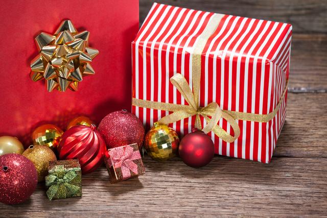 Christmas decorations and gifts placed beautifully on a wooden surface. Perfect for holiday greeting cards, festive advertisements, social media posts, and blogs about holiday preparations or Christmas celebrations.
