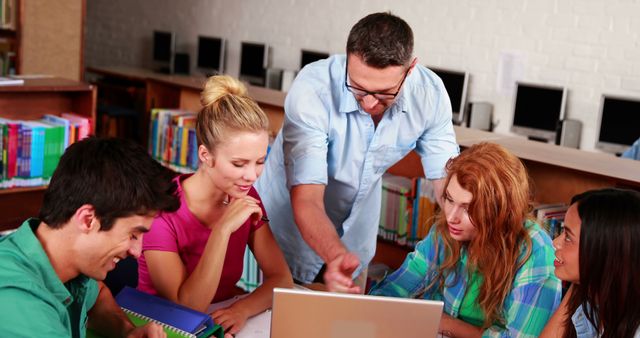 Teacher assisting college students studying in library - Download Free Stock Images Pikwizard.com