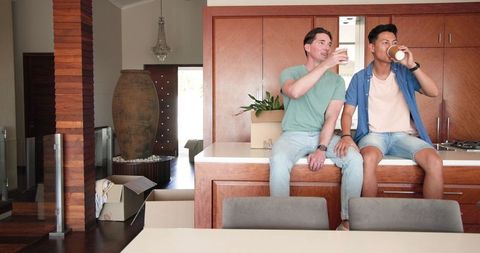 Diverse couple sharing coffee on kitchen counter at home