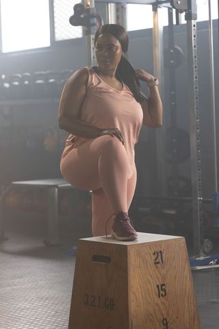 Plus-size african american woman performing plyo box step-up for strength training and fitness