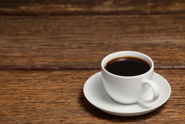 Cup of black coffee on wooden table