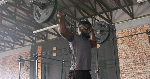 Determined Athlete Lifting Barbell in Industrial Gym