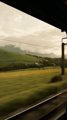 Train Window Racing Through Pastoral Valley Vertical Travel Video Showing Rolling Fields
