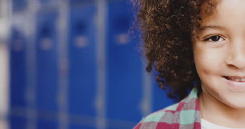 Joyful Child Smiling in School Hallway with Blue Lockers