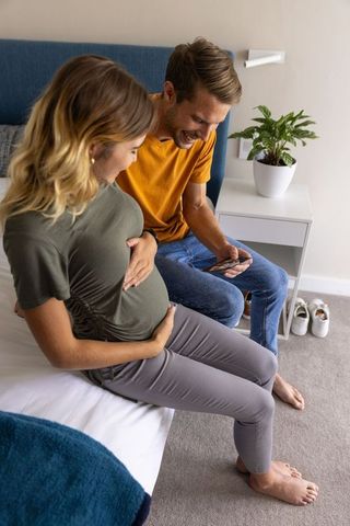 Excited Couple Enjoying Pregnancy Journey Together at Home