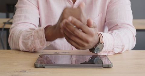 Business professional with smartwatch and tablet at desk