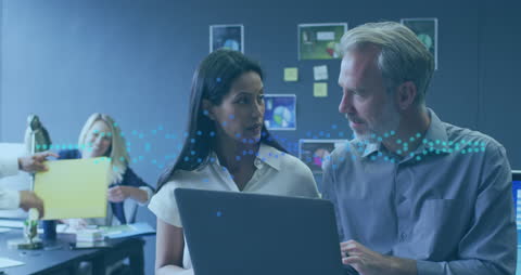 Diverse Colleagues Analyzing Data Trends on Laptop in Modern Office