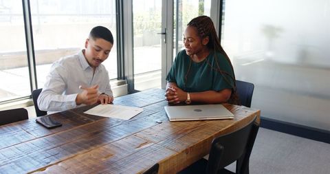 Business Professionals Signing Agreement in Modern Office Setting