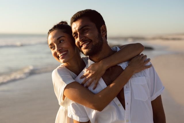 Happy young couple embracing each other on the beach