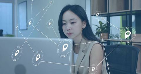 Woman in Blazer Working on Laptop with Holographic Map Network