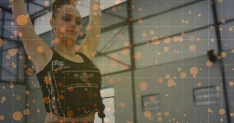 Teen dancer stretching with digital infographic overlay in bright studio