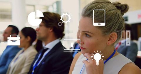 Thoughtful businesswoman listening at corporate seminar with digital icons overlaying scene