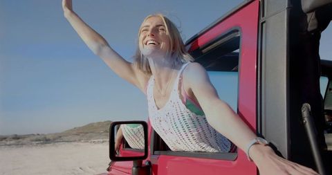 Carefree Woman Enjoying Sunny Ride Among Coastal Sand Dunes