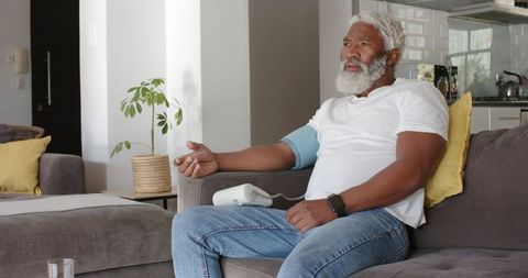 Senior African American Man Measuring Blood Pressure in Living Room