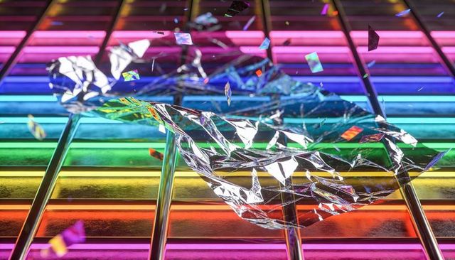 Shimmering crumpled foil reflecting rainbow led bars, iridescent confetti and prism glow