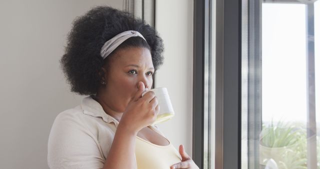 Contemplating Young Woman Drinking Coffee by Window - Download Free Stock Images Pikwizard.com