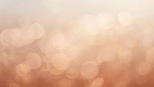 Warm peach-beige bokeh background with soft golden glow abstract light texture for marketing