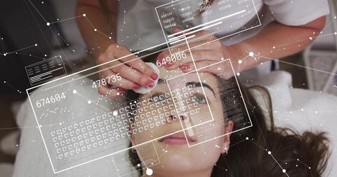Esthetician applying facial cotton pad with futuristic hud overlay for skincare tech