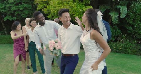 Joyful Outdoor Wedding Celebration with Diverse Friends Dancing