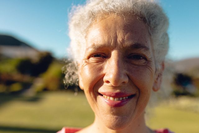 Close-up portrait of caucasian senior woman with gray hair against clear blue sky in yard in summer - Download Free Stock Photos Pikwizard.com