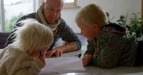 Father Encouraging Young Children's Drawing Skills at Home